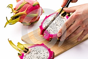 Cutting Off A First Fruit Chip From A Pitaya Half photo